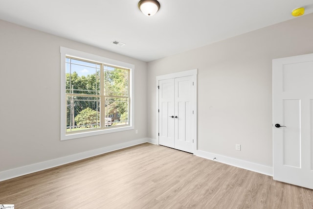 unfurnished bedroom with a closet and light hardwood / wood-style flooring