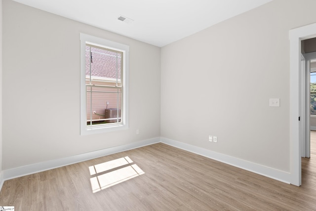 spare room featuring light hardwood / wood-style floors and a healthy amount of sunlight