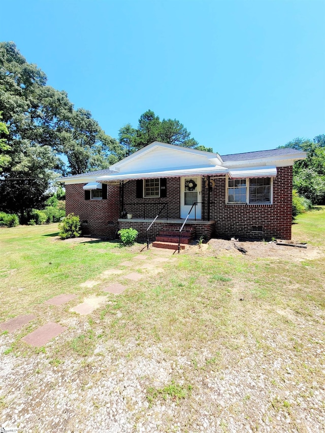 ranch-style home with a front lawn and a porch