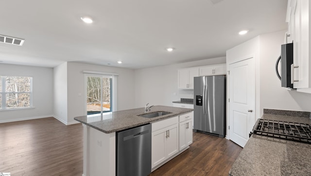 kitchen with sink, stone counters, a kitchen island with sink, stainless steel appliances, and white cabinets