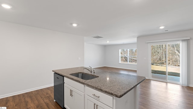 kitchen with sink, white cabinetry, dishwasher, dark stone counters, and a kitchen island with sink