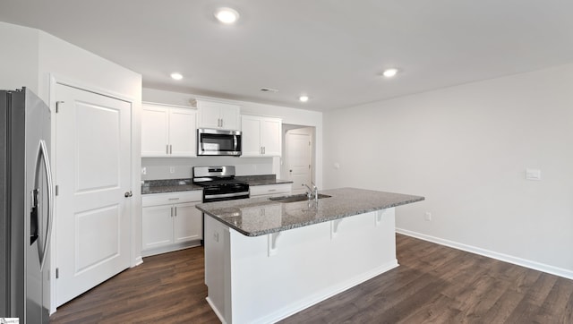 kitchen with white cabinetry, appliances with stainless steel finishes, sink, and a center island with sink