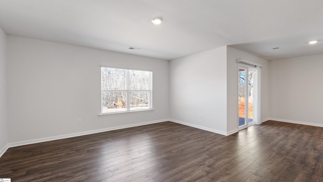 unfurnished room with dark hardwood / wood-style flooring and a wealth of natural light