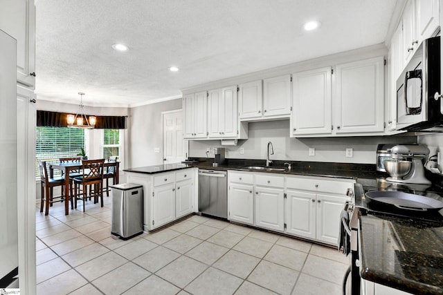 kitchen featuring decorative light fixtures, sink, white cabinetry, and stainless steel appliances