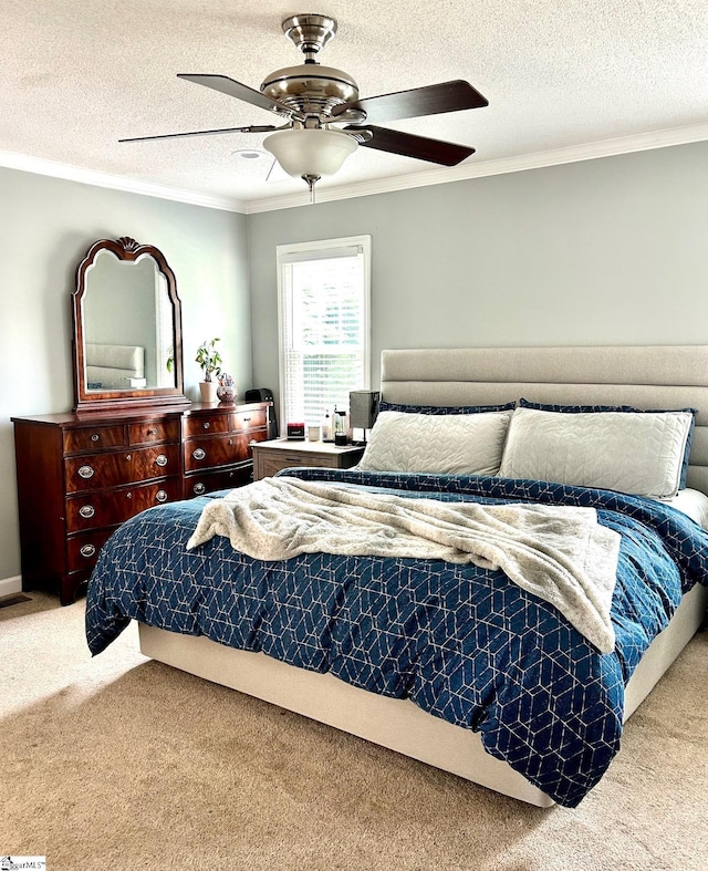 bedroom with carpet, ceiling fan, ornamental molding, and a textured ceiling