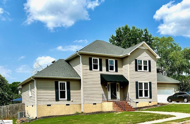 front facade with a front yard, a garage, and central air condition unit