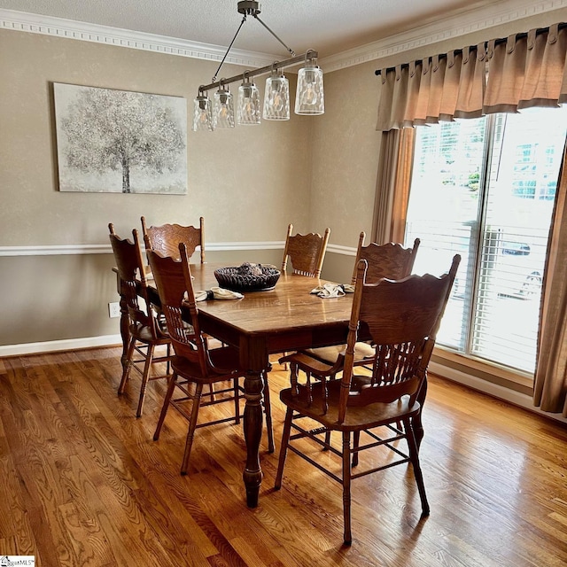 dining area featuring crown molding and hardwood / wood-style floors