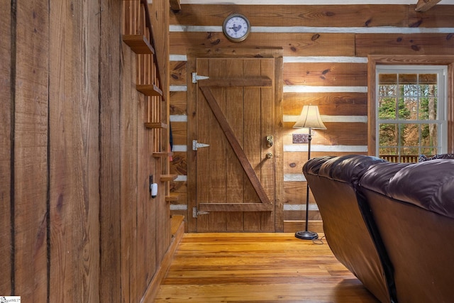 interior space featuring wooden walls and light hardwood / wood-style flooring