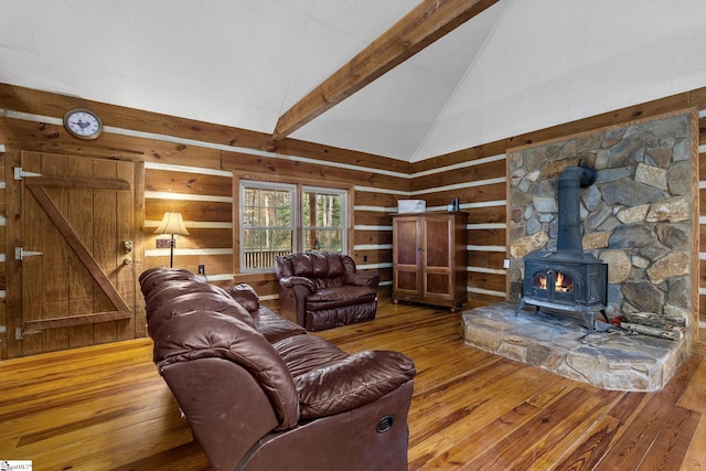 living room with a wood stove, wooden walls, lofted ceiling, and hardwood / wood-style flooring