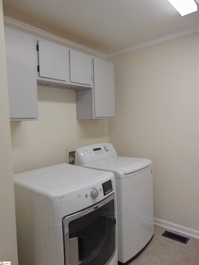 laundry room with cabinets, light tile patterned floors, washer and clothes dryer, and ornamental molding