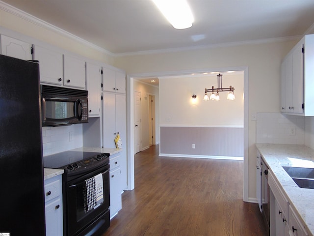 kitchen featuring white cabinets, hanging light fixtures, crown molding, and black appliances