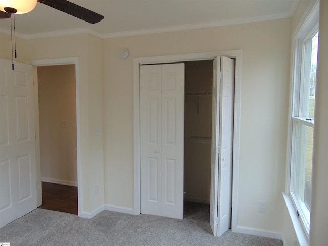 unfurnished bedroom with ceiling fan, light colored carpet, and crown molding