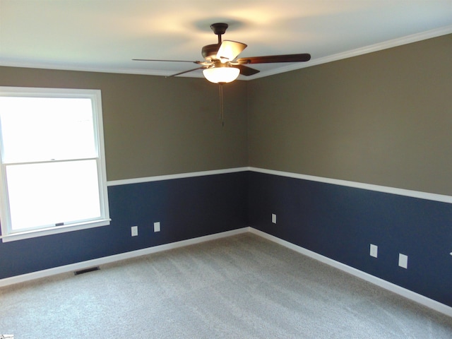 carpeted spare room with ceiling fan and ornamental molding