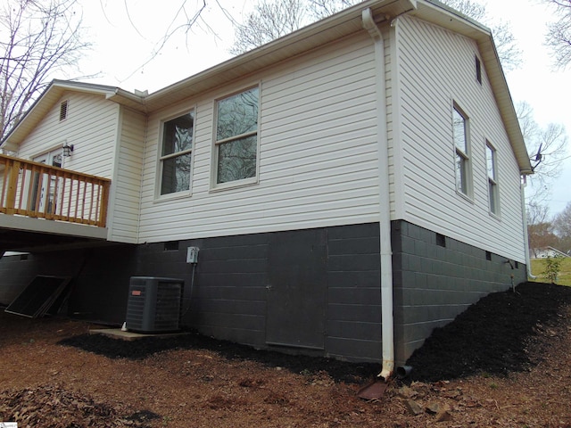 view of property exterior with a wooden deck and central AC