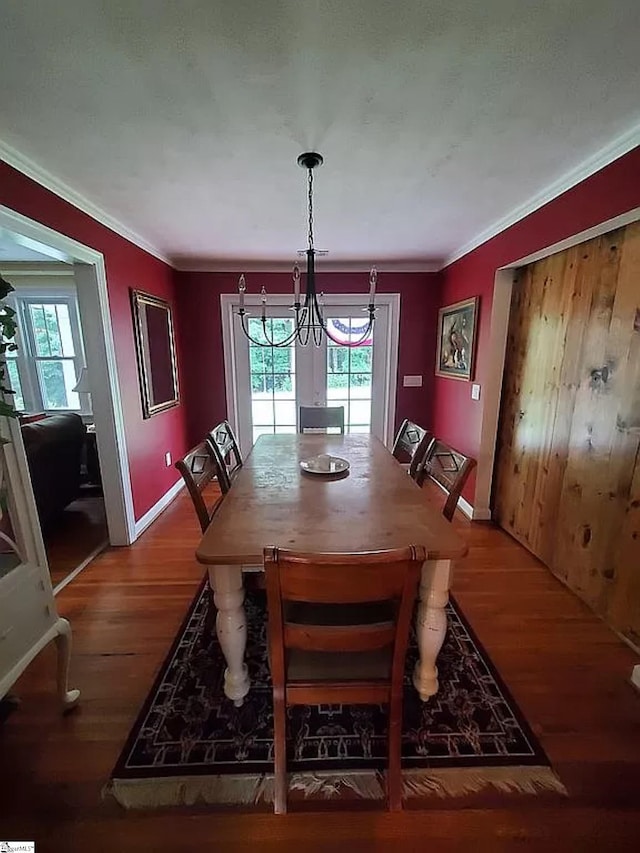 dining area with hardwood / wood-style floors, crown molding, and a healthy amount of sunlight