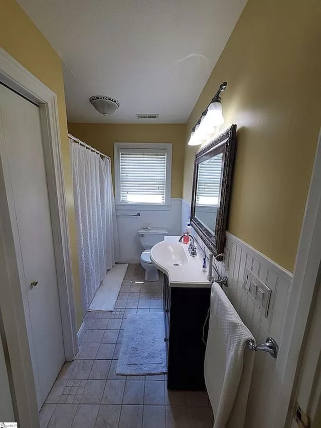 bathroom with tile patterned flooring, vanity, and toilet