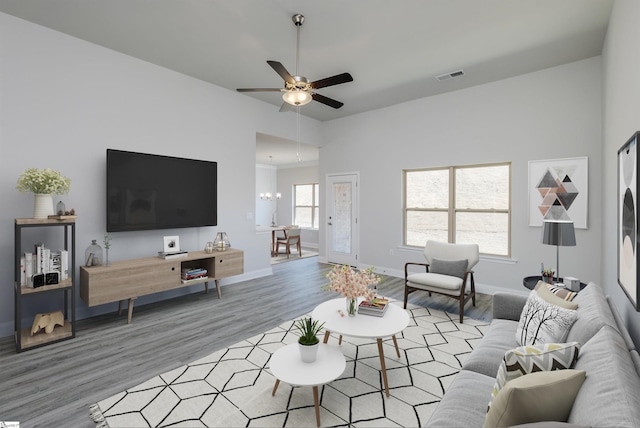 living room featuring light wood-style floors, a wealth of natural light, visible vents, and baseboards