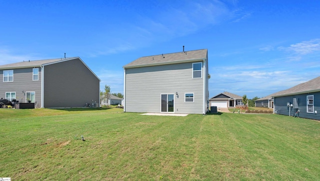 rear view of house featuring a lawn and a garage