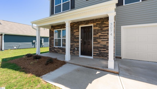 doorway to property with a garage and covered porch