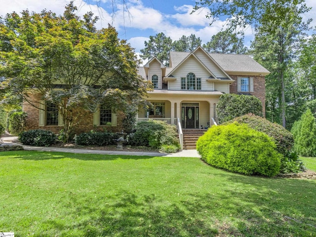 view of front of property featuring covered porch and a front lawn