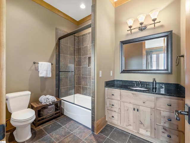 full bathroom with vanity, toilet, bath / shower combo with glass door, and crown molding