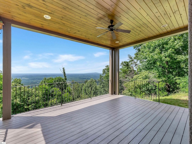 wooden terrace with a water view and ceiling fan