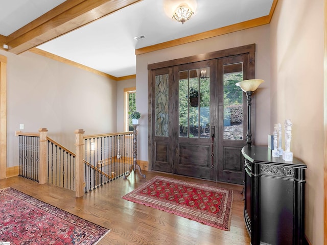 foyer with wood-type flooring and ornamental molding