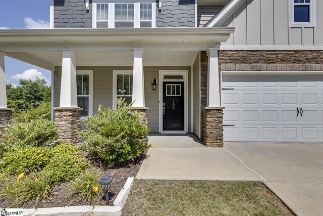 entrance to property featuring covered porch and a garage