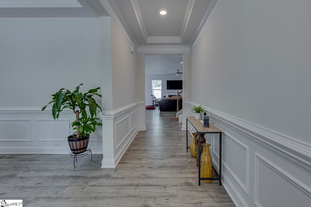 hall with ornamental molding and light wood-type flooring