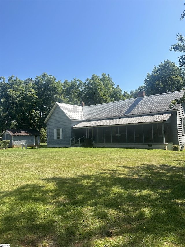 rear view of property with a sunroom and a yard