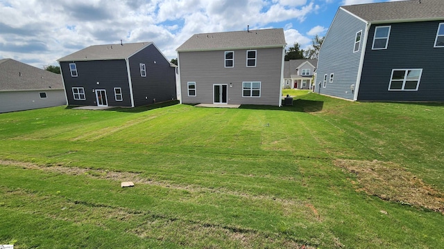 back of property with a lawn, a patio area, and central AC