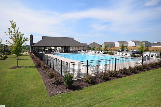 view of pool featuring a lawn