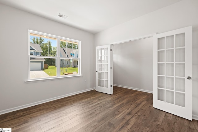 unfurnished room featuring dark hardwood / wood-style flooring and french doors