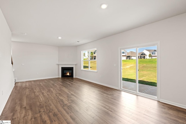 unfurnished living room featuring dark hardwood / wood-style floors and a healthy amount of sunlight