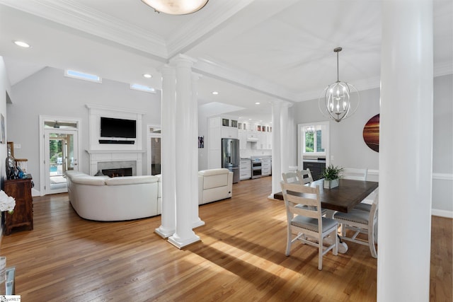 living room with crown molding, light wood-type flooring, and ornate columns