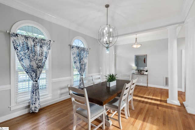 dining room featuring ornamental molding, decorative columns, and light hardwood / wood-style flooring