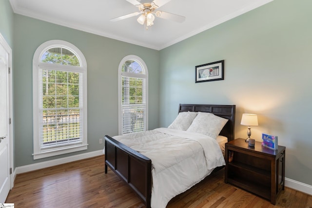 bedroom with dark wood-type flooring, ceiling fan, and ornamental molding