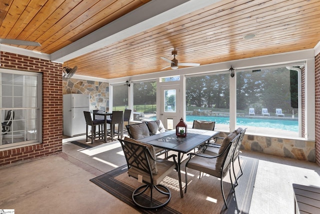 sunroom featuring ceiling fan, wooden ceiling, and a healthy amount of sunlight