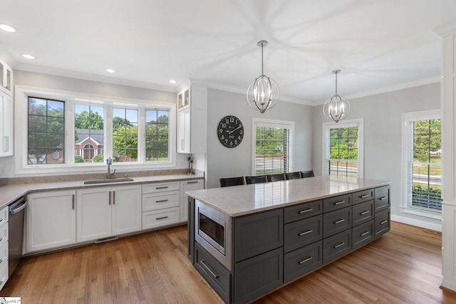 kitchen featuring white cabinetry, appliances with stainless steel finishes, sink, and hanging light fixtures