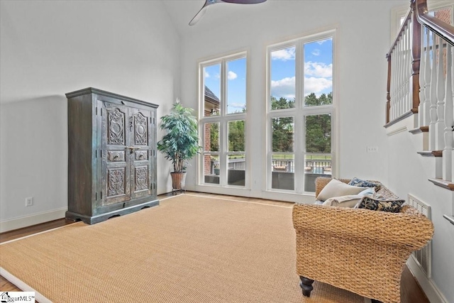 living area featuring ceiling fan and high vaulted ceiling