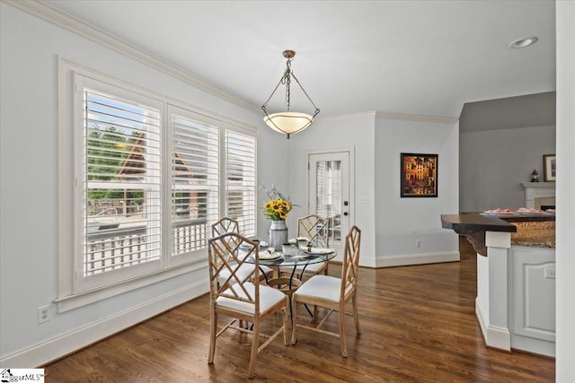 dining space with dark hardwood / wood-style flooring and crown molding