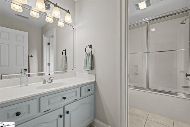 bathroom with tile patterned floors, vanity, and bath / shower combo with glass door