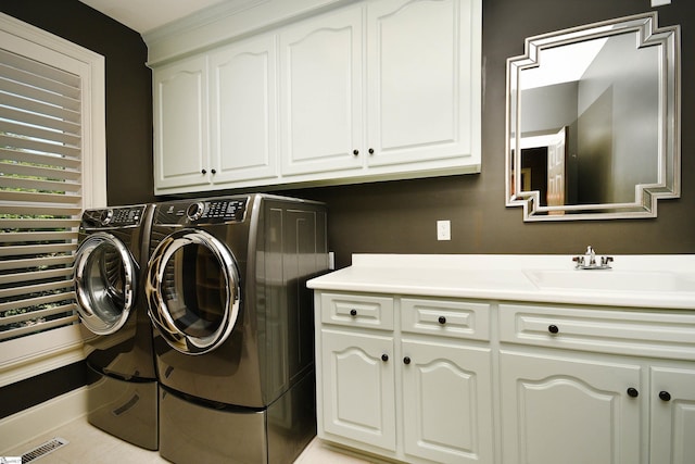 laundry room featuring cabinets, light tile patterned floors, sink, and washing machine and dryer