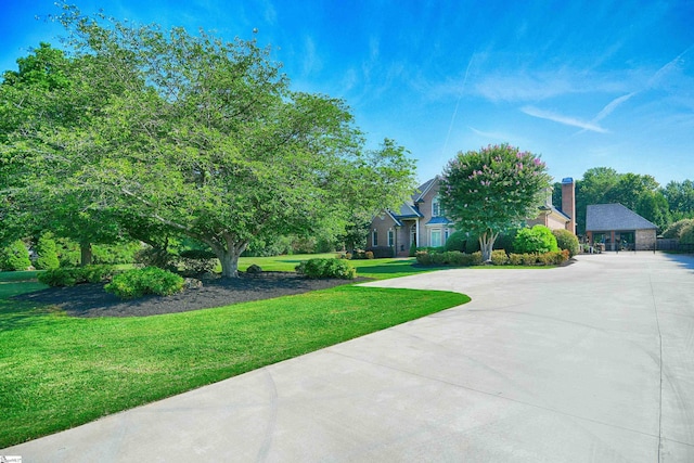 view of property hidden behind natural elements featuring a front yard