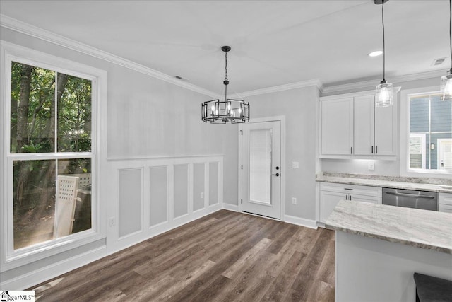 unfurnished dining area with ornamental molding, plenty of natural light, dark wood-type flooring, and a chandelier