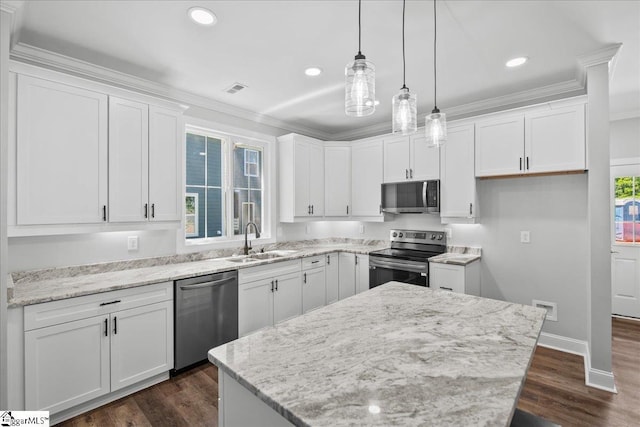 kitchen featuring stainless steel appliances, sink, a kitchen island, and white cabinets