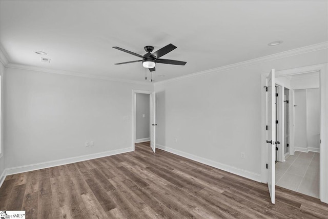 empty room featuring hardwood / wood-style flooring, ornamental molding, and ceiling fan