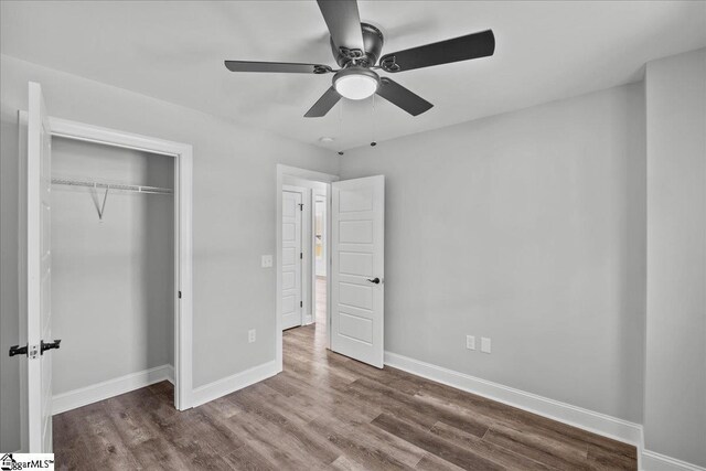 unfurnished bedroom with ceiling fan, hardwood / wood-style floors, and a closet