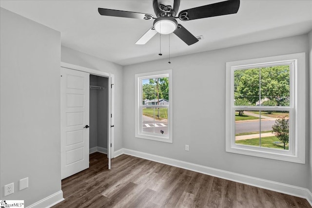 unfurnished bedroom featuring ceiling fan, dark hardwood / wood-style flooring, and a closet