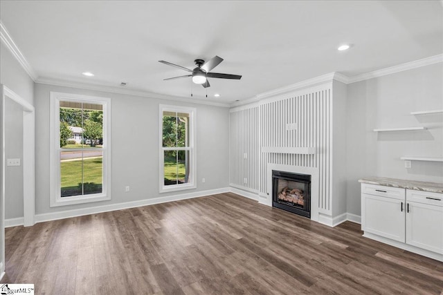 unfurnished living room featuring a large fireplace, ornamental molding, dark hardwood / wood-style floors, and ceiling fan